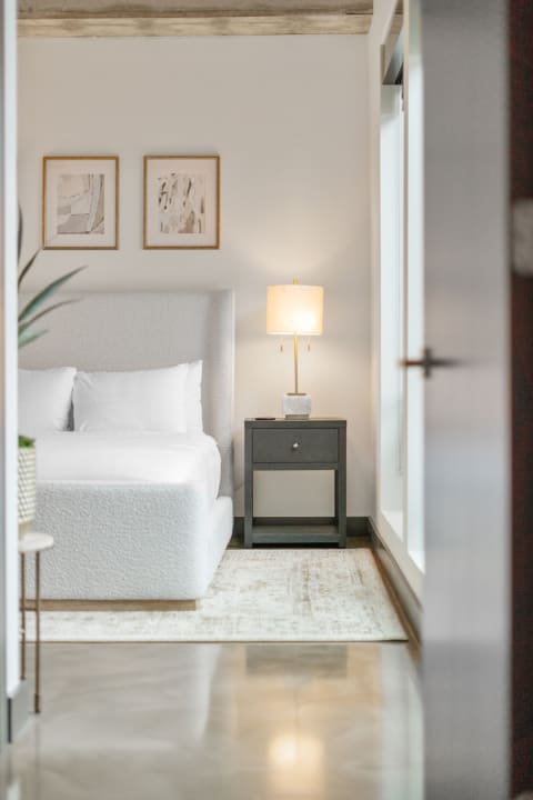 Modern bedroom featuring a white upholstered bed and minimalist decor.