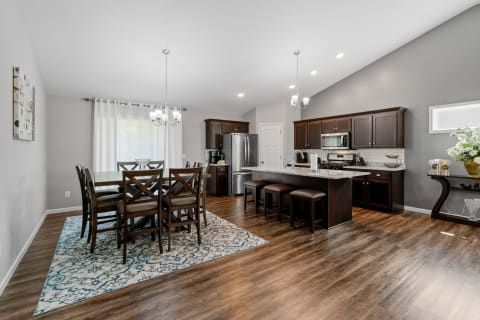 Interior of a contemporary kitchen and dining area with dark wood furniture and modern appliances.