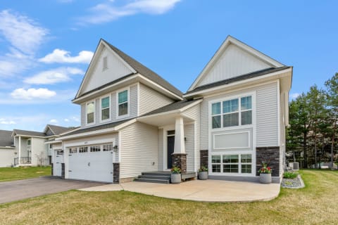 A modern two-story home with large windows and a welcoming entrance.