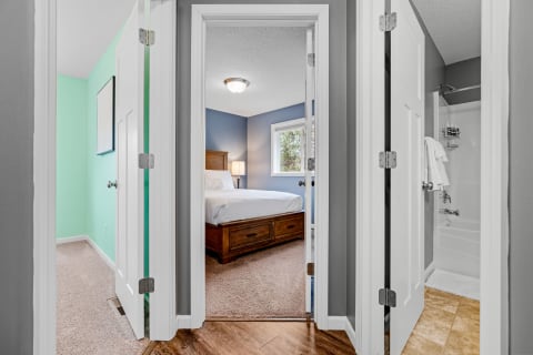 View of a bright and inviting hallway leading to a cozy bedroom and bathroom.