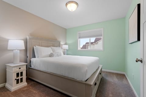 Cozy bedroom featuring a double bed, side lamps, and mint green walls.