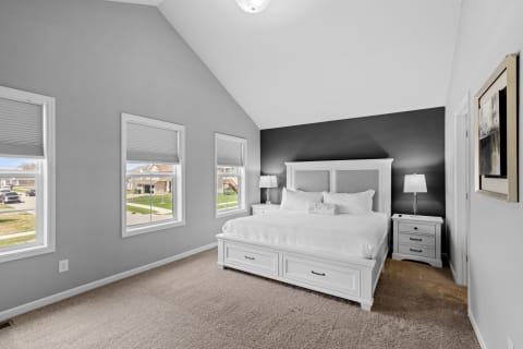 A beautifully designed bedroom featuring a large bed, elegant decor, and bright natural light.