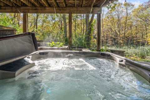 Hot tub with bubbling water in a forested area.