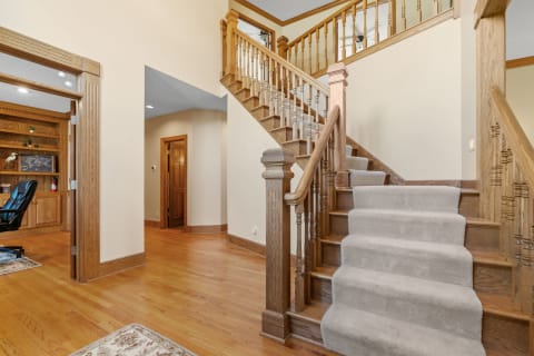 Entrance area featuring a wooden staircase and oak cabinetry.