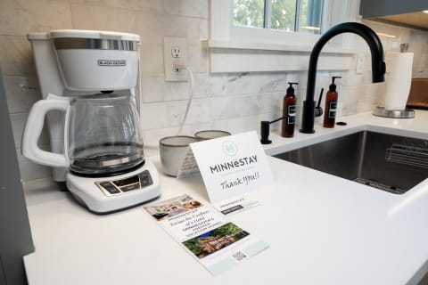 A modern kitchen counter with a coffee maker, two bowls, and a thank you card from MINNESTAY.