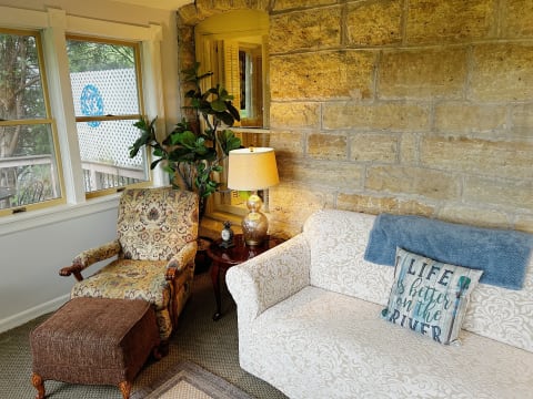 A cozy living room featuring stone walls, plush seating, and warm lighting.