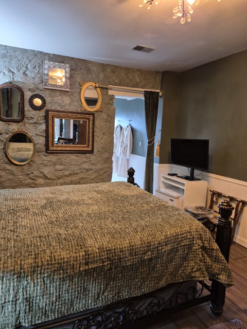 Luxurious bedroom featuring a plush king bed, decorative mirrors, and soothing colors.