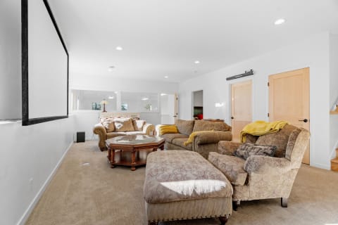 Spacious lounge with upholstered furniture and a large projection screen.