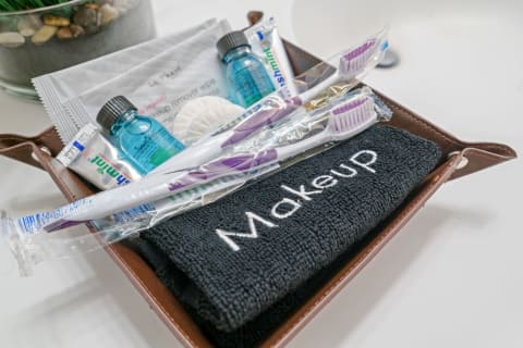 Tray of personal care items including a makeup towel, toothbrushes, and makeup remover supplies.