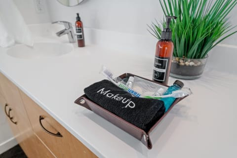 Bathroom countertop with a brown tray containing toiletries and a black towel labeled 'MakeUp'.
