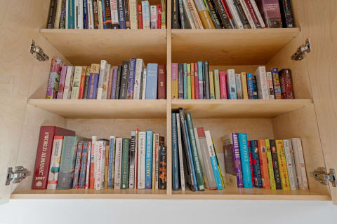 A wooden bookshelf brimming with assorted books, showcasing a colorful collection.