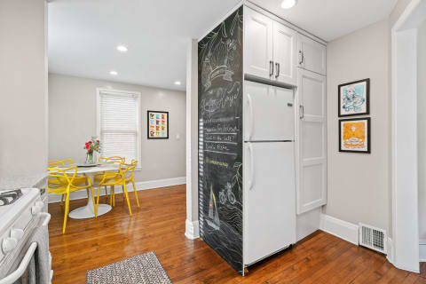 Bright kitchen featuring a yellow dining set and a chalkboard refrigerator.