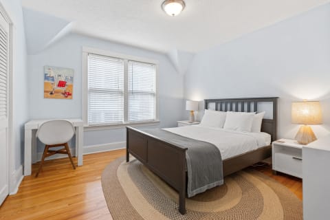 Cozy bedroom with blue walls, a comfortable bed, and a work desk.