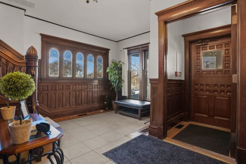 A stylish entrance hall featuring wooden paneling and stained glass windows.