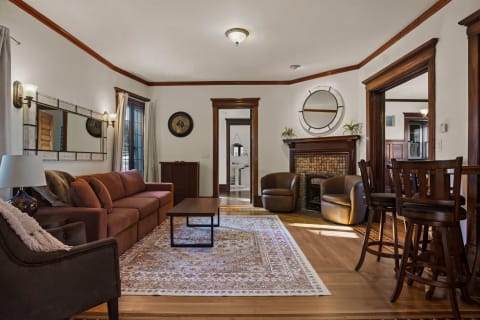 Cozy living room featuring a rust-colored sofa, wooden furniture, and elegant decor.