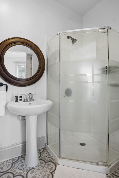 Contemporary bathroom with glass shower enclosure and vintage pedestal sink.
