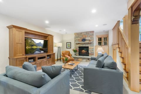 Comfortable living room featuring light blue sofas and a stone fireplace.