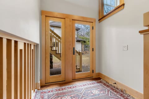 Interior view of an entryway with double doors and a decorative rug.