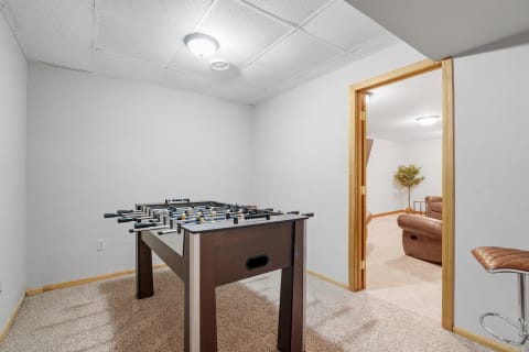Interior view of a game room featuring a foosball table and an open doorway to another space.