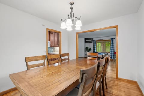 Spacious dining area with a wooden table and adjoining kitchen view.
