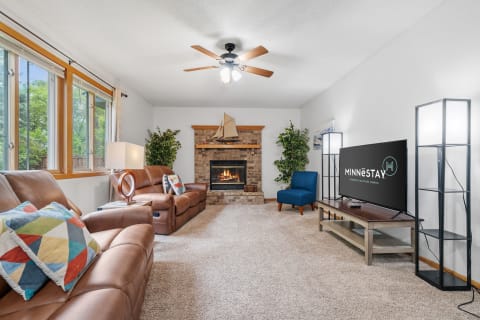 A cozy living room featuring leather recliners, a fireplace, and a television.
