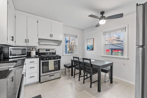 Modern kitchen featuring a black table and white cabinets.