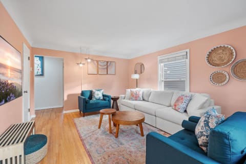 Inviting living room with a gray sofa, teal chairs, and decorative wall art.
