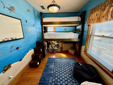 Children's bedroom with underwater-themed walls, a bunk bed, and a cozy rug.