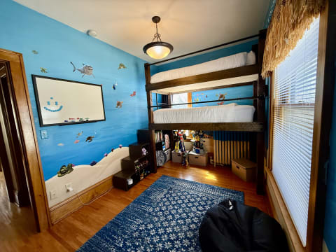 Children's bedroom with ocean-themed decor, bunk bed, and colorful marine life on the walls.