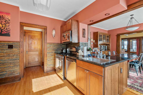 Cozy kitchen featuring terracotta walls and wooden accents with modern appliances.