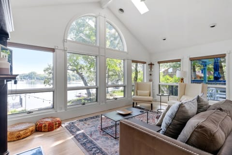 Cozy lakeside living room with large windows and comfortable seating.