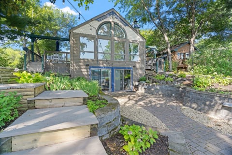 Modern house with large windows and lush gardens.