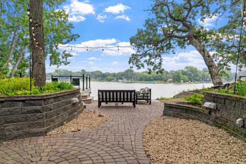 Lakeside seating area with a view of the water and greenery.