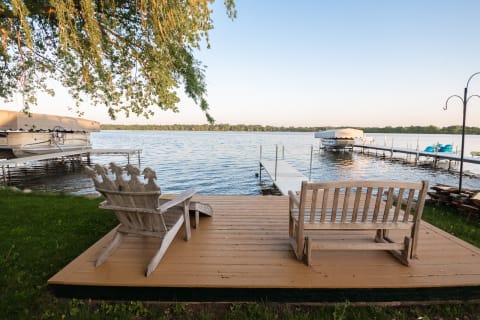Lakeside scene featuring wooden seating and a calm water view.