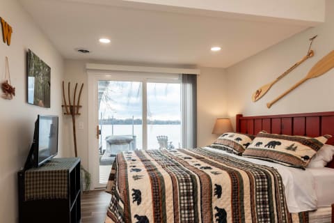 Cozy bedroom with lake views, featuring a quilted bedspread and rustic decor.