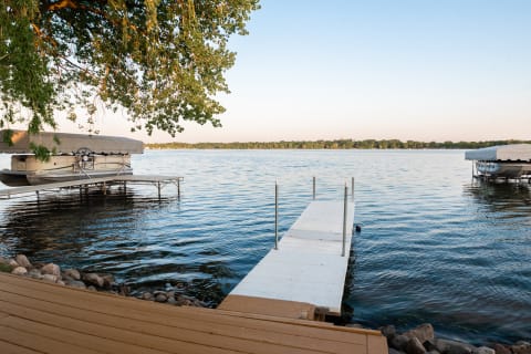 Lakeside view with a wooden dock and a boat.