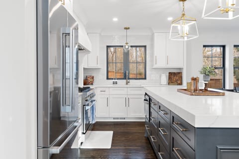 Modern kitchen featuring a white marble island and dark gray cabinets.