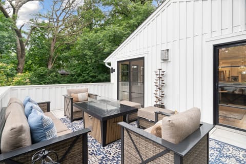 Cozy outdoor patio featuring a sectional sofa and view of greenery.