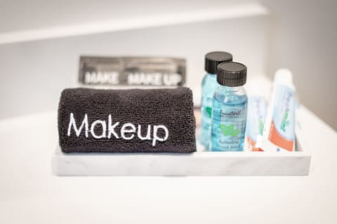 A tray with a black towel labeled 'Makeup,' mouth wash bottles, and a toothpaste tube.