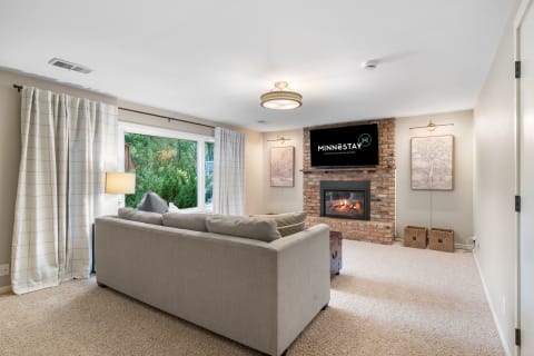 Cozy living room with a sectional sofa and a brick fireplace.