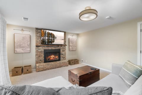 Cozy living room with fireplace, artwork, and a wooden trunk.