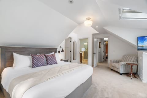 Charming bedroom featuring a king-sized bed and cozy reading area.