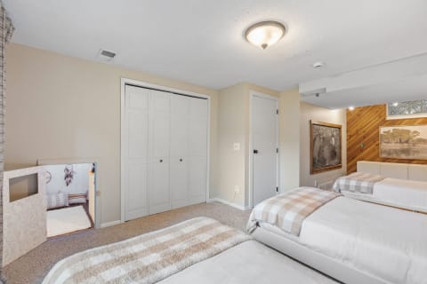 A spacious bedroom featuring twin beds and a unique play area door.
