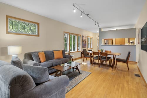 Relax in your spacious open-plan living area with plush seating and warm hardwood floors that flow seamlessly into the dining space.