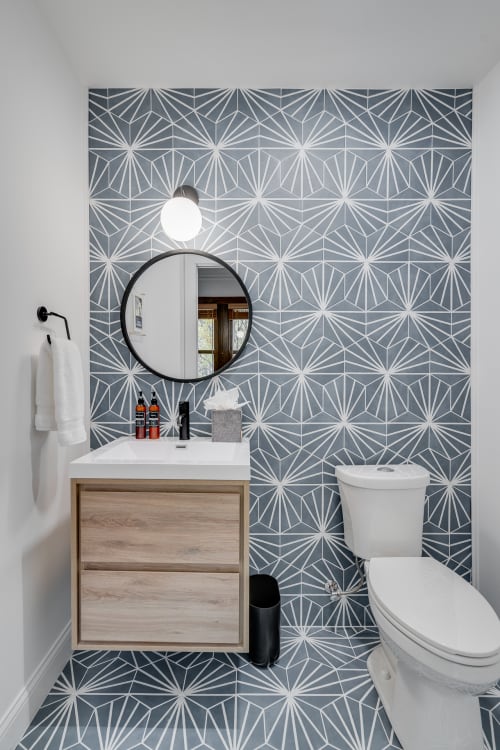 You'll love this stylish powder room with stunning geometric tiles and modern floating vanity for your daily routine.