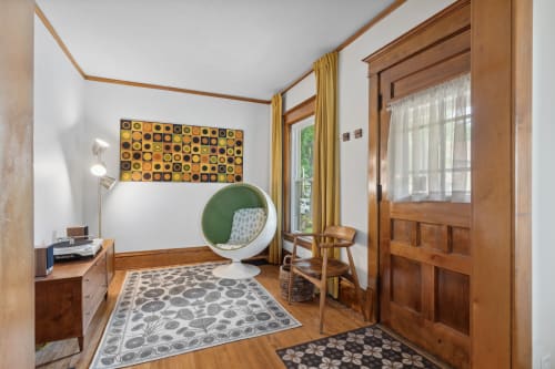 A mid-century modern styled corner featuring an egg-shaped chair and vintage music setup.