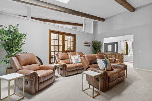 Sink into plush leather recliners beneath rustic beams where comfort meets style in your spacious living area.