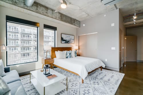 Relax in your stylish loft bedroom with exposed concrete, mid-century furnishings, and city views right outside your windows.
