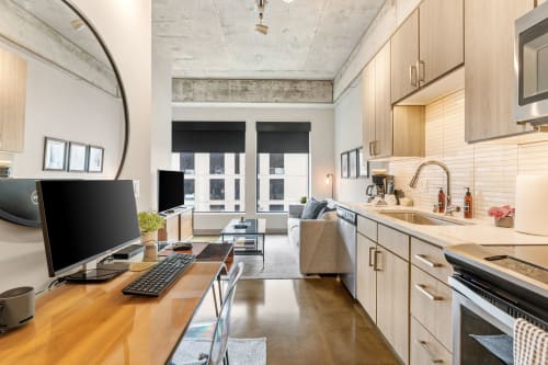 Your modern studio seamlessly blends work and relaxation with sleek kitchen, cozy seating, and bright city views.