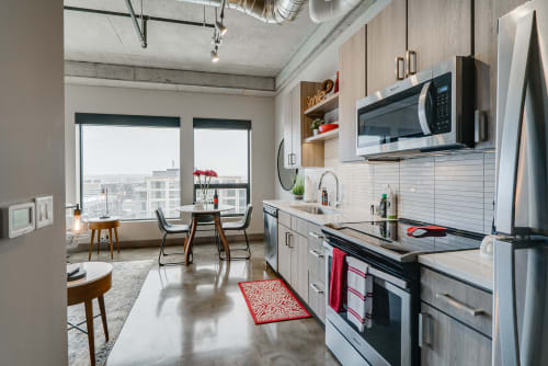Your modern kitchen features sleek appliances and bright city views, perfect for cooking meals while enjoying the urban panorama.